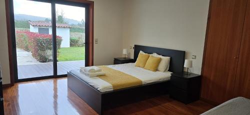 a bedroom with a bed and a large window at Petit Maison in Além da Ribeira