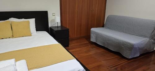 a hotel room with two beds and a bed and a chair at Petit Maison in Além da Ribeira