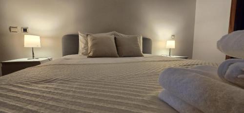 a bedroom with a large bed with two lamps at Petit Maison in Além da Ribeira