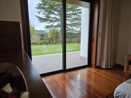 a room with a sliding glass door to a patio at Petit Maison in Além da Ribeira