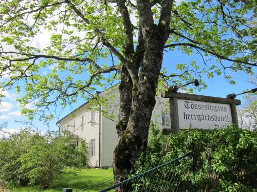 a sign on a tree in front of a building at Tössestugan in Tösse