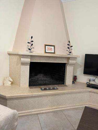 a living room with a fireplace with a tv at violeta's house in Sivota