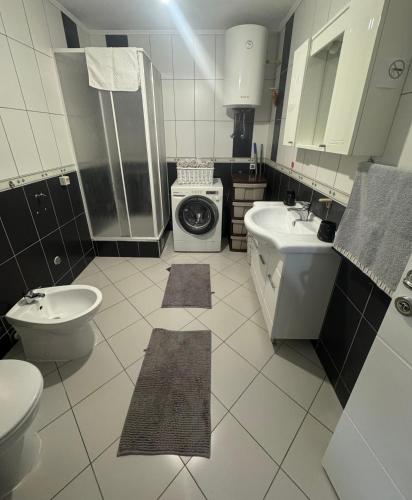 a bathroom with a toilet sink and a washing machine at Anes' apartment in Mostar