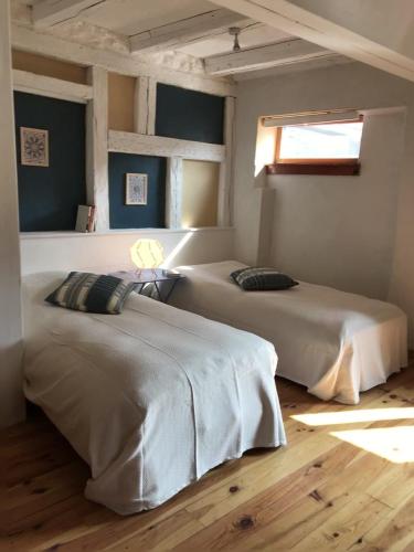 deux lits dans une chambre avec une fenêtre dans l'établissement Odile en Bleu in Barr, à Barr