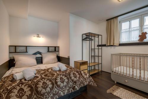 a bedroom with a large bed and a crib at NA-Home Kitzbühel Hornbichl in Kitzbühel