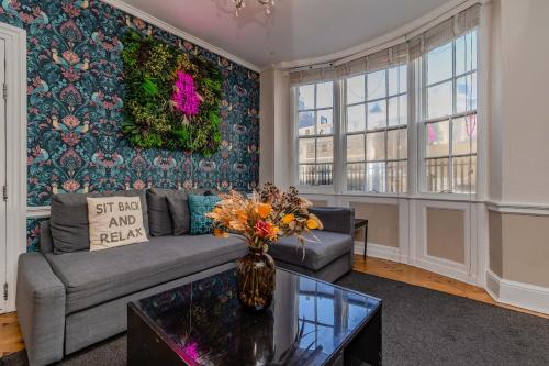 a living room with a couch and a vase of flowers at Super Central Town House Next To Brighton Beach in Brighton & Hove