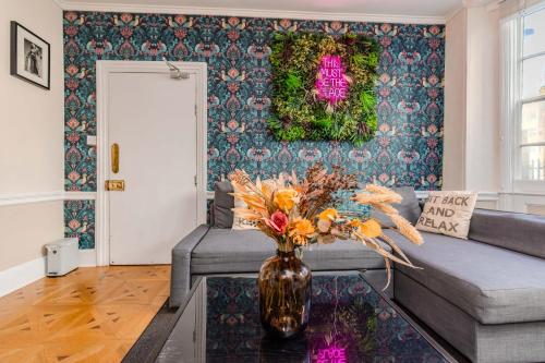 a living room with a couch and a vase with flowers at Super Central Town House Next To Brighton Beach in Brighton & Hove
