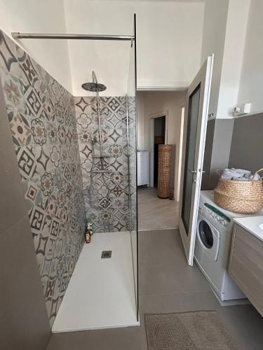 a bathroom with a shower and a washing machine at Holly's House apartment in Alzano Lombardo