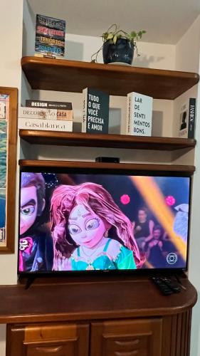 a flat screen tv sitting on top of a shelf at Apartamento Matteo in Ubatuba