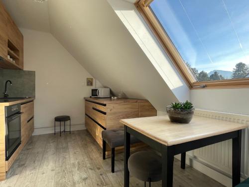 a kitchen with a dining table and a window at Apartmán Kubín in Dolný Kubín