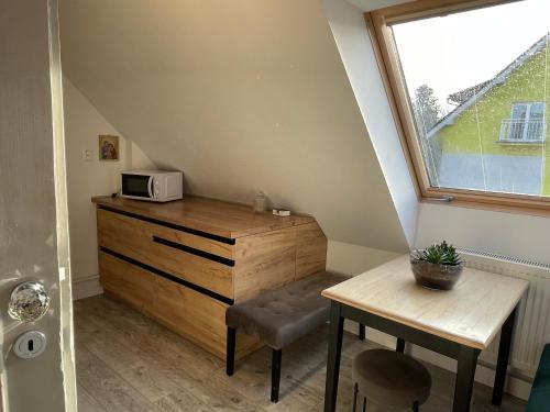 a small room with a wooden dresser and a microwave at Apartmán Kubín in Dolný Kubín