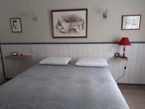 une chambre avec un grand lit avec deux oreillers dans l'établissement Maison esperantza, à Saint-Pée-sur-Nivelle