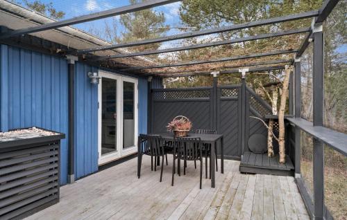 a pergola on a deck with a table and chairs at 2 Bedroom Nice Home In Højby in Højby