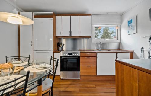 a kitchen with white cabinets and a table with a dining room at 2 Bedroom Nice Home In Højby in Højby