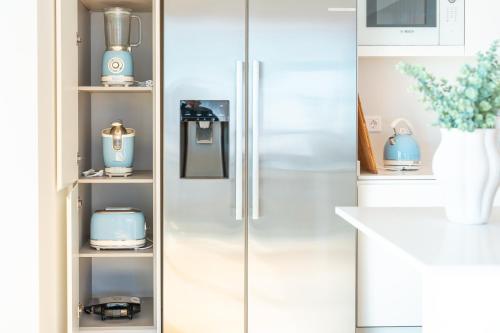 a white refrigerator in a kitchen with blue appliances at Suite 5P Madeira Acqua Residence in Funchal