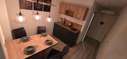 a kitchen with a wooden table with chairs and lights at Apartma Minka in Miklavž pri Ormožu