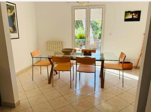 une salle à manger avec une table et des chaises en verre dans l'établissement Villa indépendante avec piscine, à San-Gavino-di-Carbini
