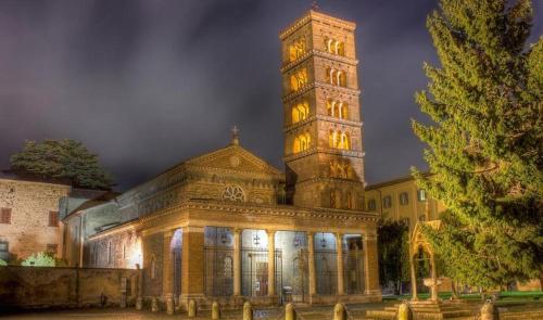 a large building with a clock tower at night at Villa Abbamer in Grottaferrata
