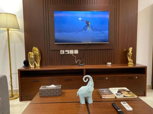 a living room with a television and a table with a swan on it at Luxury One Bed Apartment Goldcrest Grand Mall and Residency DHA LHR in Lahore