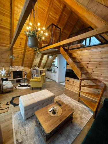 a living room with a staircase in a cabin at Villas Sunny Hill in Žabljak