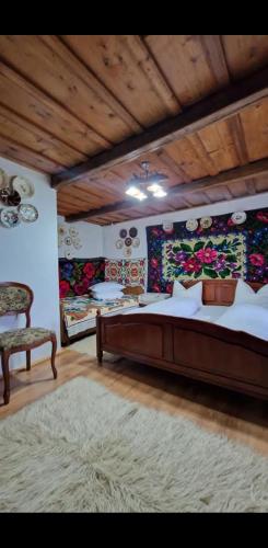 a bedroom with a large bed and a rug at Pensiunea Rustic Oncesti in Onceşti