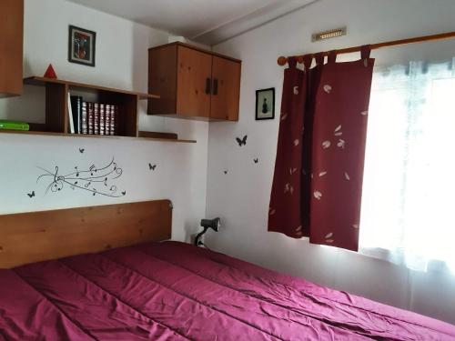 - une chambre avec un lit avec des draps roses et une fenêtre dans l'établissement Esperantza, à Saint-Pée-sur-Nivelle