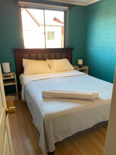 a bedroom with a bed with a blue wall at Hostal Brisa Serena in Santiago