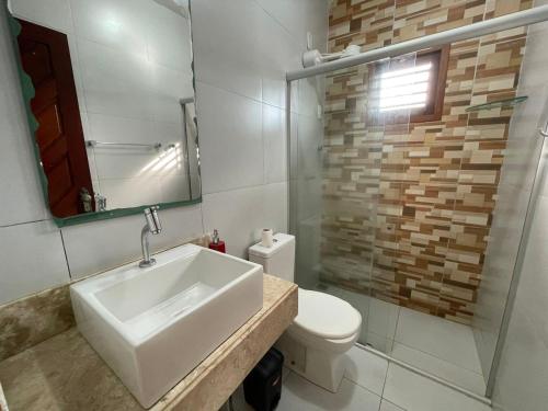 a bathroom with a sink and a toilet and a mirror at Flat em NATAL- RN in Natal