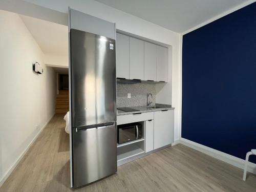 a kitchen with a stainless steel refrigerator in a room at Romantic Downtown Studio in Vila do Conde