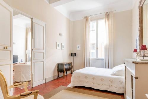 une chambre blanche avec un lit et un bureau dans l'établissement Bel appartement près du Cours Mirabeau, à Aix-en-Provence