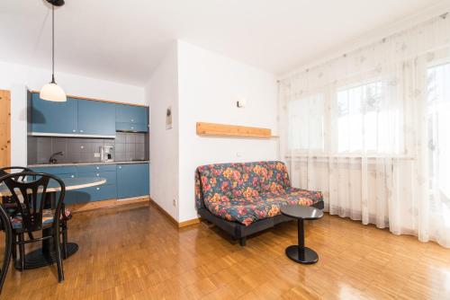 a living room with a couch and a kitchen at Residence Auriga in Campo Tures