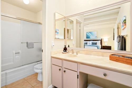 a bathroom with a sink and a toilet and a mirror at Keiki Honu Kauai Princeville 2BR2BA King+Queen bed in Princeville