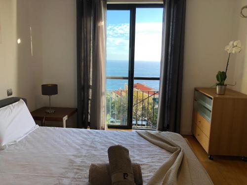 ein Schlafzimmer mit einem Bett mit Blick auf das Meer in der Unterkunft Forum Ocean View Apartment in Funchal