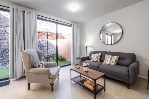 a living room with a couch and a table and a mirror at Olivia's home in Zibata Queretaro in La Cañada