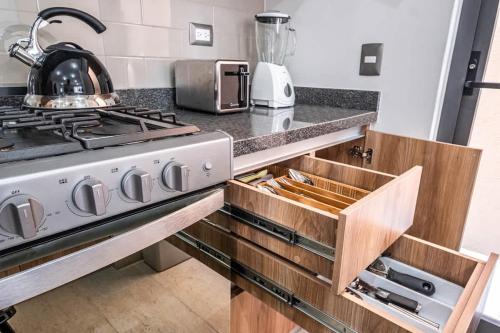 a kitchen with a stove and a sink at Olivia's home in Zibata Queretaro in La Cañada