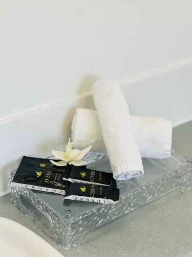 a glass tray with towels and a flower on it at AAA Northlands Motel in Christchurch