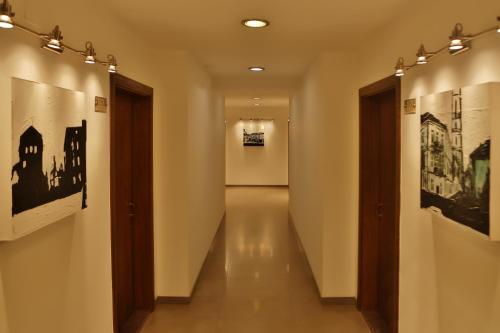 a hallway with paintings on the walls of a museum at Hotel Centrum Prizren in Prizren