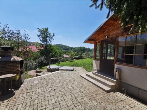 une maison avec une terrasse en briques à côté d'un bâtiment dans l'établissement Eva's Garden, à Breaza