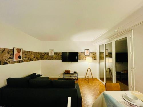 un salon avec un canapé et une télévision dans l'établissement Studio Palais des Congrès Maillot Paris, à Paris