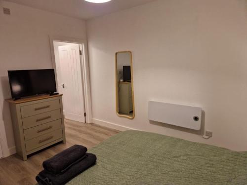 a bedroom with a bed and a tv and a mirror at Highbanks in Newhaven