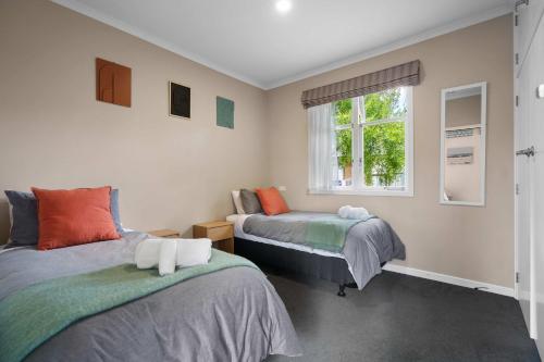 a bedroom with two beds and a window at Charming 3 Bedroom Family Home Pet Friendly in Hamilton