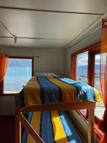 a bedroom with a bed with a view of the ocean at Baguales Patagonia in Puerto Cisnes
