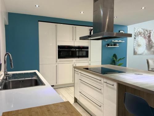 a kitchen with white cabinets and blue walls at l'imperial WIFI & Confort in Brussels