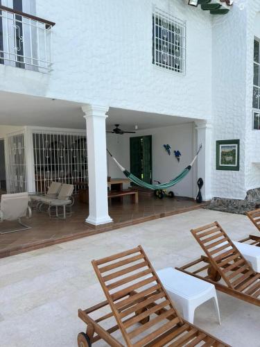 a porch with chairs and a hammock on a house at PASEOS GRANDES!!!-14 PAX-Hacienda Manantiales Paraíso Natural in Fredonia