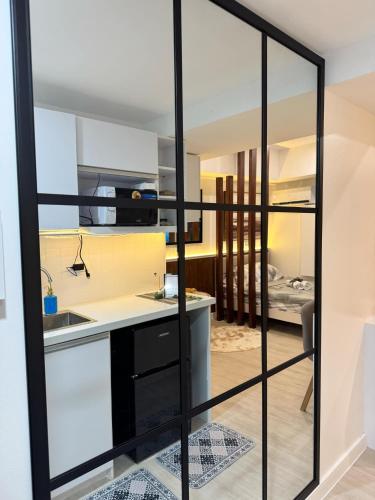 a kitchen with sliding glass doors leading into a living room at La Rynaz - Azure North in Pampang