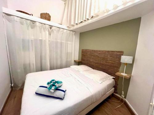 une chambre avec un lit avec un chapeau dessus dans l'établissement Studio bohème au coeur de Montpellier!, à Montpellier