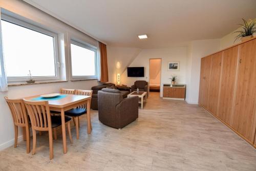 a living room with a table and a couch at Ferienwohnung NW 31 Meerblick in Duhnen