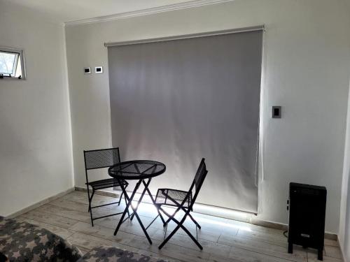 a table and two chairs in a room with a wall at La Serena in María Grande
