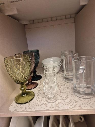 a shelf with several glass vases and bowls on it at Hanok Stay Seowa in Gyeongju