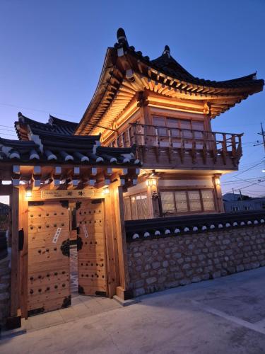 an asian building with a gate with lights on it at Hanok Stay Seowa in Gyeongju